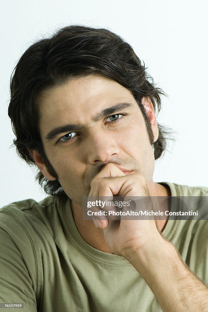 "Man with fist in front of mouth, head and shoulders, portrait"