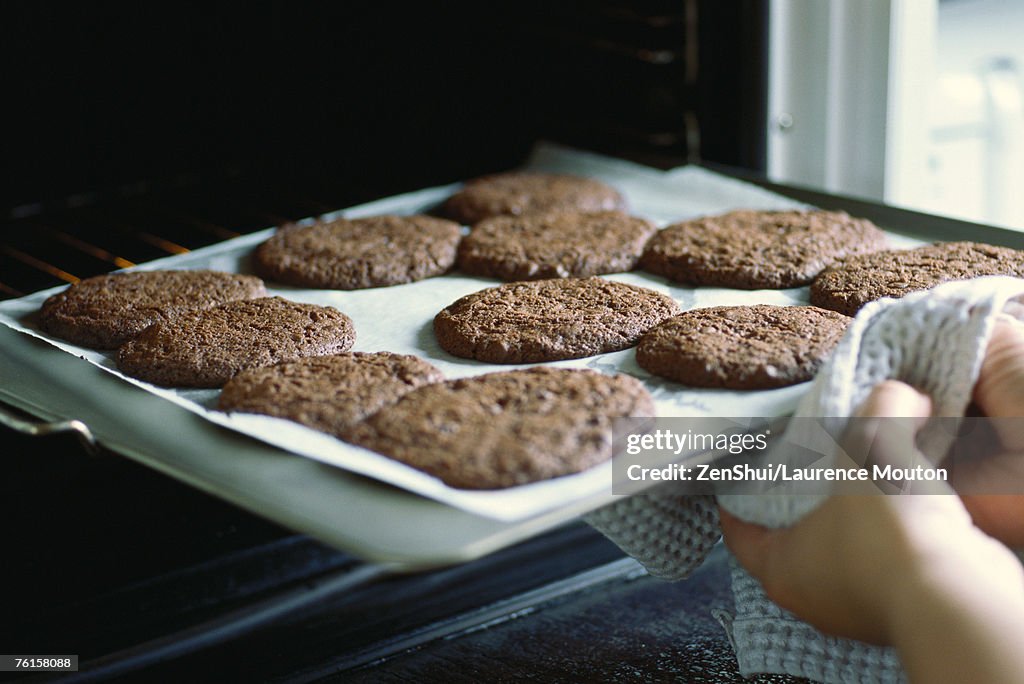 Taking sheet of cookies out of the oven