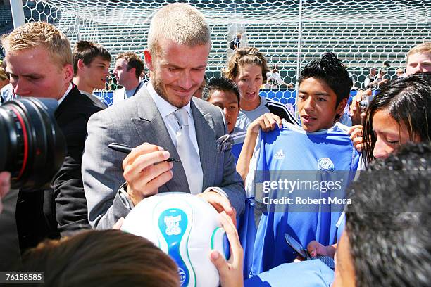 David Beckham poses signs autographs for young fans following to a press conference introducing him as the newest member of the Los Angeles Galaxy on...