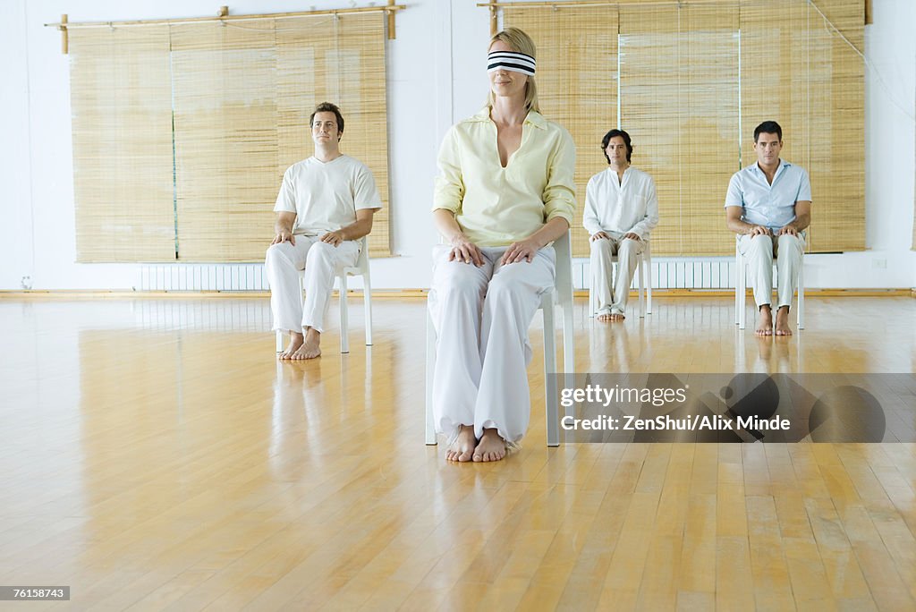 Group therapy, woman in foreground blindfolded