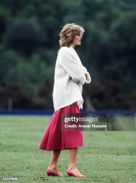 Diana, Princess of Wales, wearing a pink sailor style dress with a white collar and white mohair cardigan while pregnant with Prince Harry, attends a...