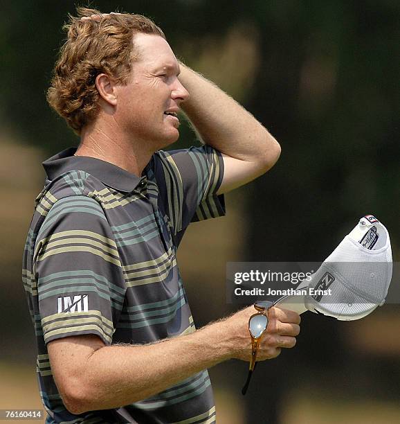 Tim Petrovic smooths his hair after finishing play at the 18th green during the second round of the Wyndham Championship at Forest Oaks Country Club...