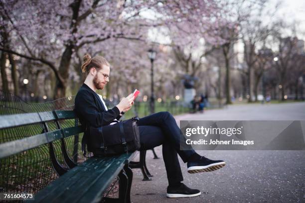 man reading on bench in park - banco de parque imagens e fotografias de stock