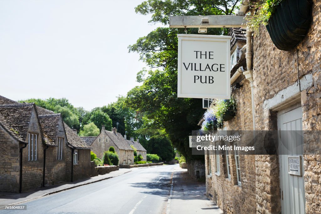 Exterior view of village pub with sign advertising available rooms.