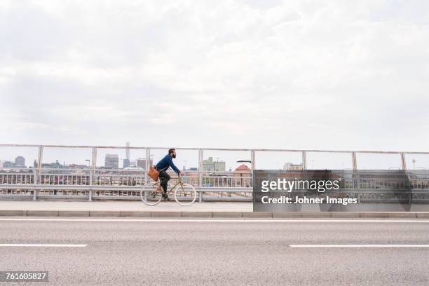 man cycling on street - street side stock-fotos und bilder
