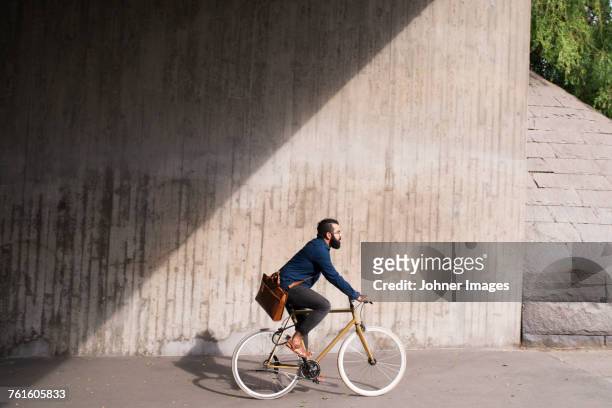 man cycling on street - radfahren stock-fotos und bilder