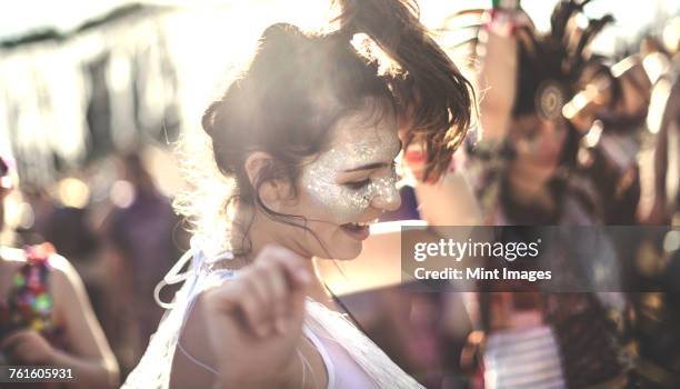 young woman at a summer music festival dancing among the crowd. - one young woman only stock pictures, royalty-free photos & images