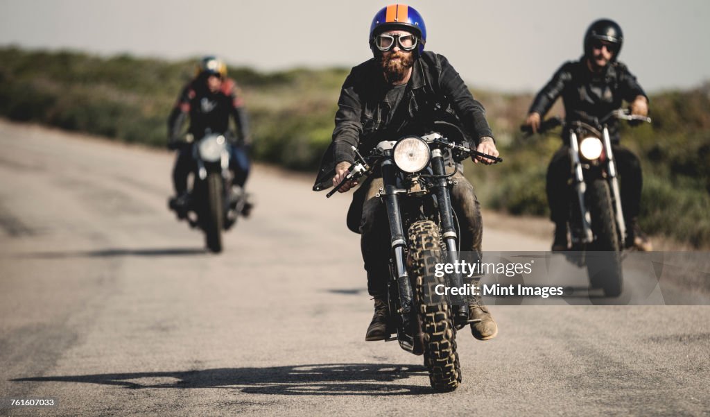 Three Men Wearing Open Face Crash Helmets And Goggles Riding Cafe Racer ...