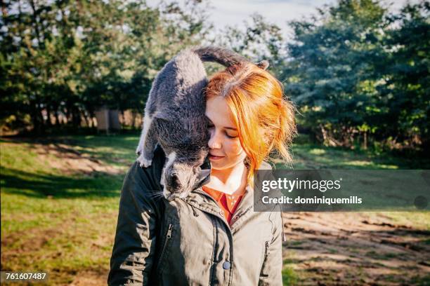 girl standing with a cat on her shoulders, viscri, brasov, romania - affectionate cat stock pictures, royalty-free photos & images