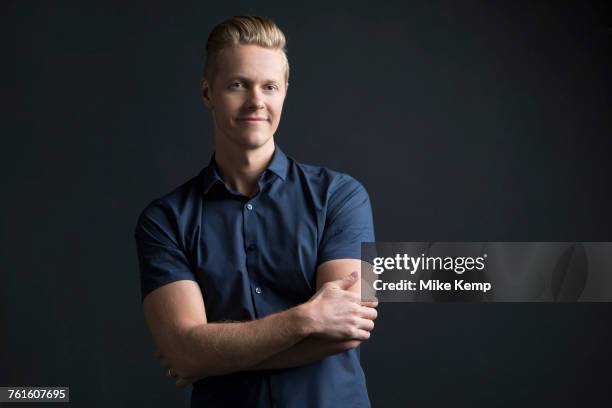 portrait of man with crossed arms on black background - black background portrait stockfoto's en -beelden