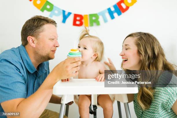 mother and father celebrating first birthday of daughter (12-17 months) - 1st birthday stock-fotos und bilder