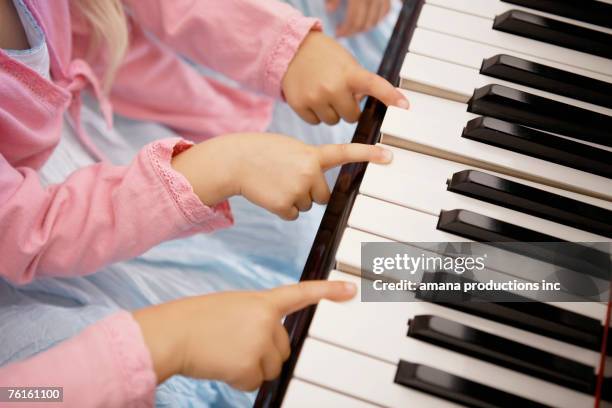 triplets playing piano (focus on hands) - wijsvinger stockfoto's en -beelden