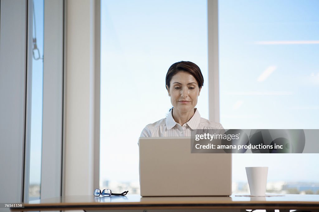 Mature woman typing with laptop computer (low angle view)