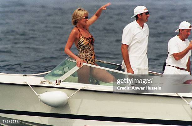 Diana, Princess of Wales, wearing an animal print, halterneck swimsuit and sunglasses, has fun on a boat on July 17, 1997 in Saint-Tropez, France.