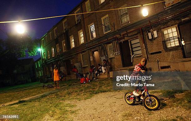 Residents gather under lights they put up themselves in the B.W. Cooper housing project August 17, 2007 in New Orleans, Louisiana. Before Hurricane...