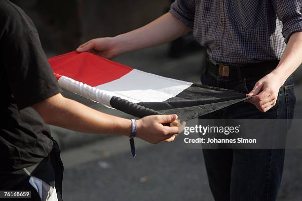 Neo-Nazis roll off a flag after being stopped during a march to commemorate the anniversary of the death of Rudolf Hess on August 18, 2007 in...
