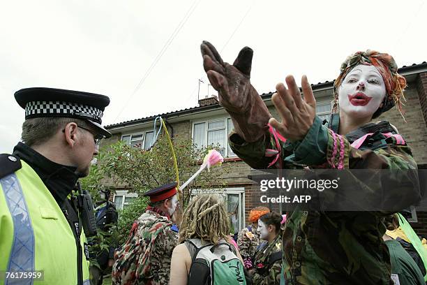 Policeman watches over costumed protesters 19 August 2007 at the Camp For Climate Action, Sipson Lane, north of Heathrow Airport, near London....