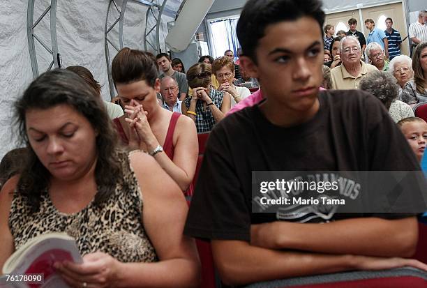 Parishioners pray during Sunday Mass at Saint Clare Catholic Church's temporary tent sanctuary August 19, 2007 in Waveland, Mississippi. The church,...