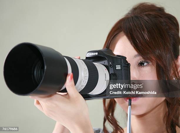 Model displays the new Canon EOS 40D digital SLR camera during a press preview on August 20, 2007 in Tokyo, Japan. The new camera features a...