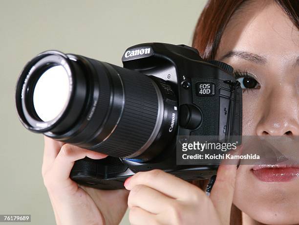 Model displays the new Canon EOS 40D digital SLR camera during a press preview on August 20, 2007 in Tokyo, Japan. The new camera features a...