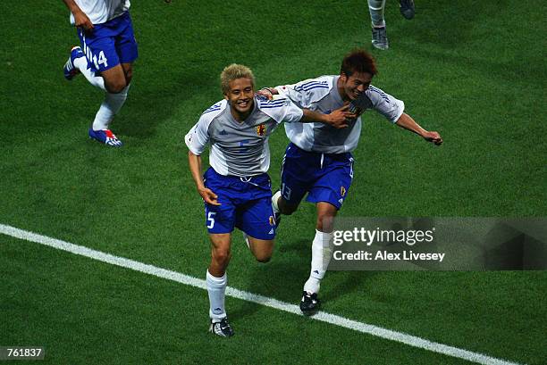 Junichi Inamoto of Japan celebrates scoring the second goal with his team mate Atsushi Yanagisawa during the Group H match against Belgium of the...