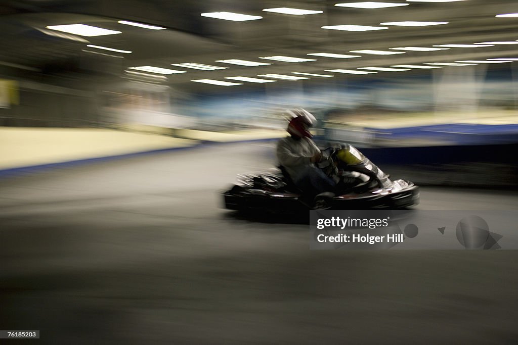 Person driving a go-cart on a race track