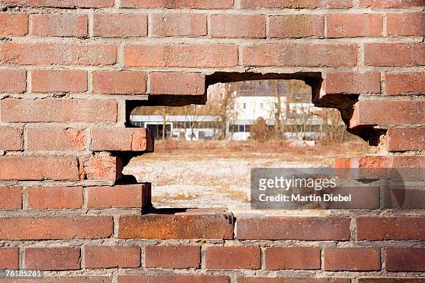 a hole in a brick wall - brick wall hole stock pictures, royalty-free photos & images