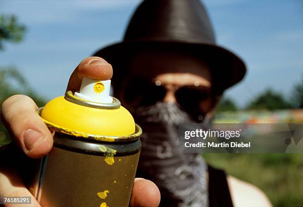 a man holding a can of spray paint - spraydose stock-fotos und bilder