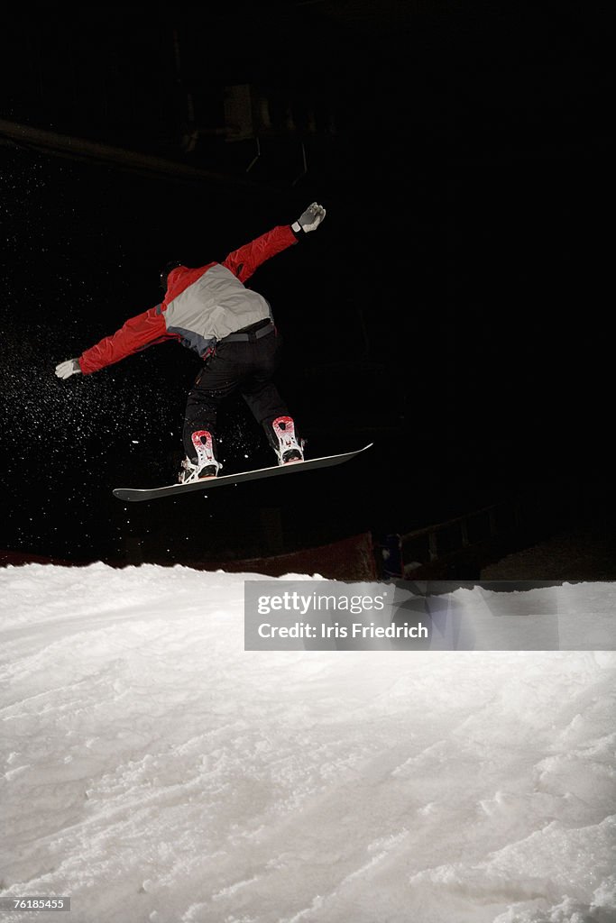 Snowboarder mid-air on a ski slope