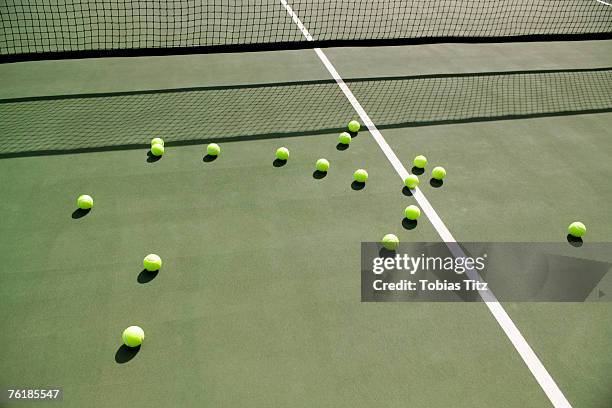 tennis balls scattered on a tennis court - balle de tennis photos et images de collection