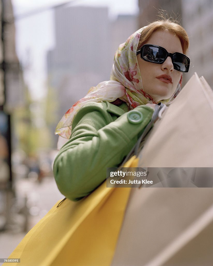 Woman carrying shopping bags and crossing a city street