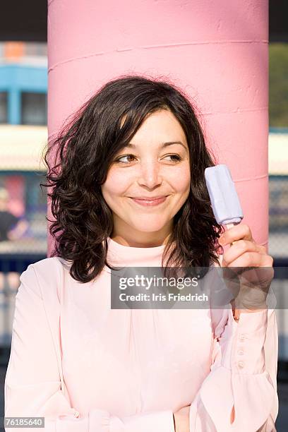 a young woman holding an ice-cream on a stick - smug stock pictures, royalty-free photos & images