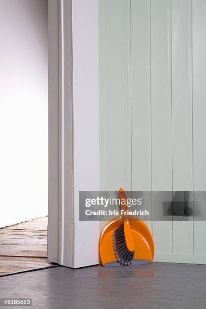 a dustpan and broom in a corner - dustpan and brush stockfoto's en -beelden