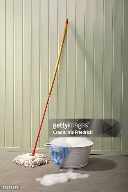 a bucket of soapy water and a mop - mop stock-fotos und bilder