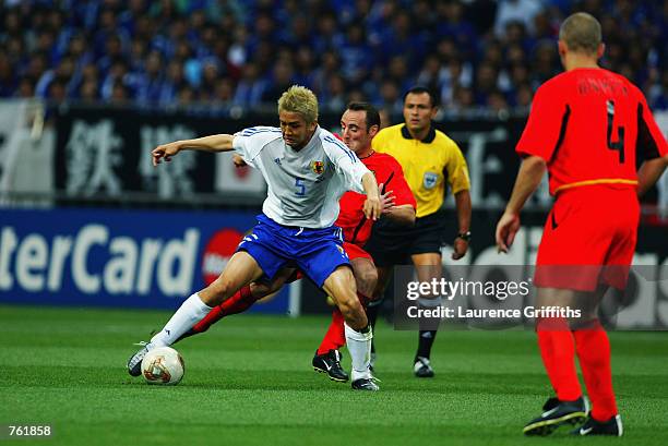 Yves Vanderhaeghe of Belgium is held off by Junichi Inamoto of Japan during the Group H match of the World Cup Group Stage played at the Saitama...