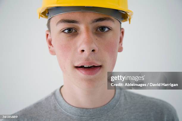 teenage boy wearing a hard hat - boy yellow shirt stock pictures, royalty-free photos & images