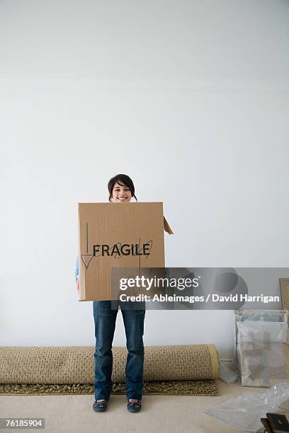a woman carrying a cardboard box - brown box stock pictures, royalty-free photos & images