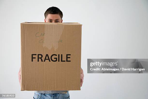teenage boy holding cardboard box - large cardboard box stock pictures, royalty-free photos & images