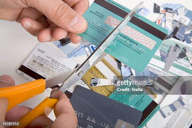 a man cutting up credit cards - credit card and stapel stockfoto's en -beelden