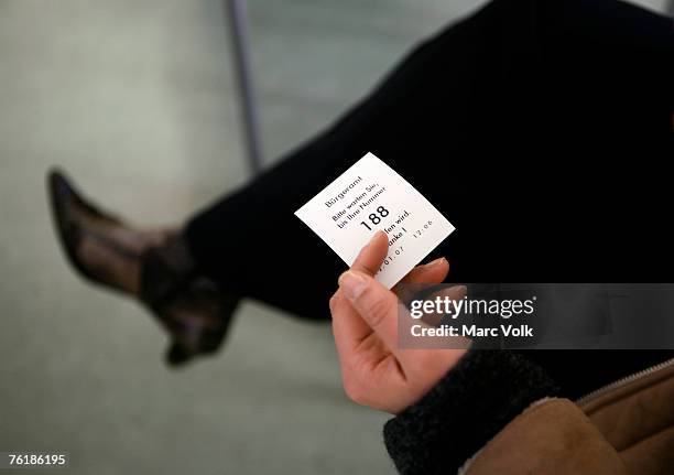 a woman holding a ticket in a waiting room - waiting room stockfoto's en -beelden