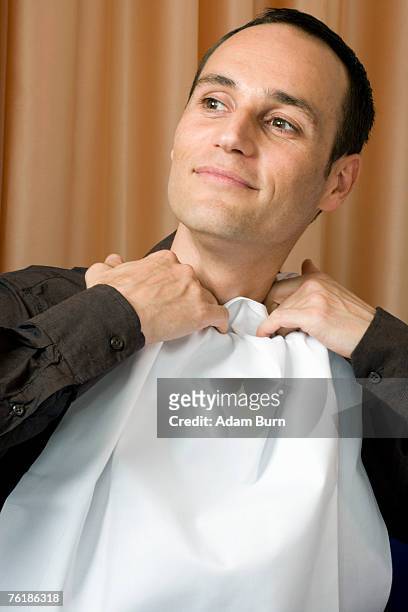 a man tucking a napkin into his shirt collar - collar stock-fotos und bilder