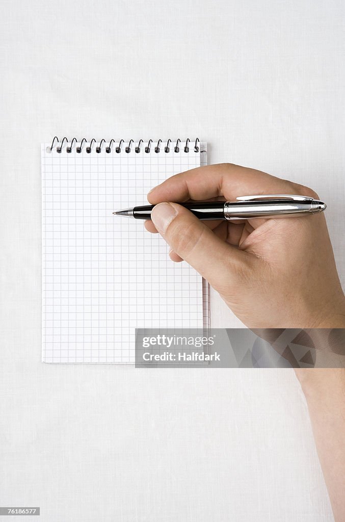 Detail of a man with a notepad and pen