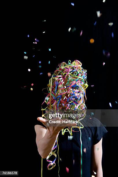 a woman covered in streamers and throwing confetti - birthday streamers stock-fotos und bilder