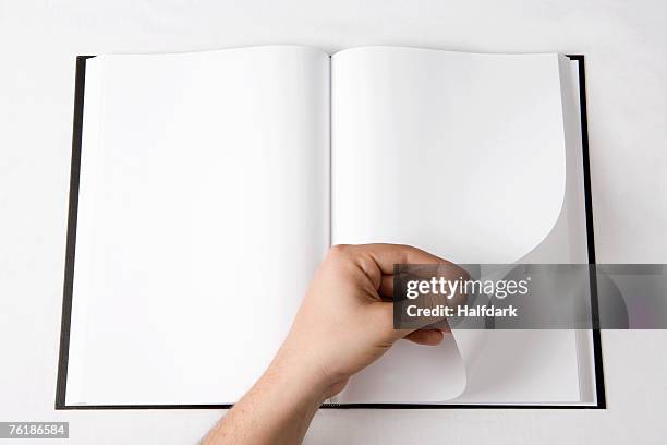 detail of a man turning a page of a blank book - turning imagens e fotografias de stock