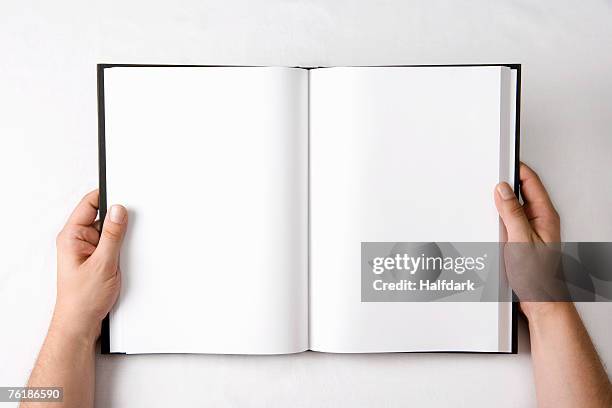 detail of a man holding an open book with blank pages - schetsblok stockfoto's en -beelden