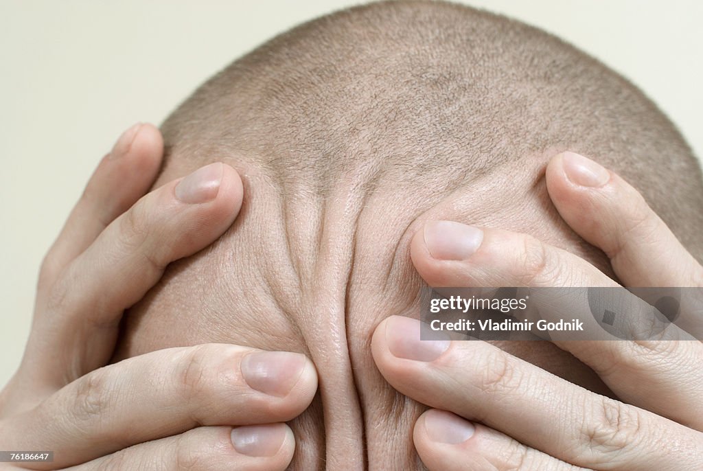 Detail of a man rubbing his head