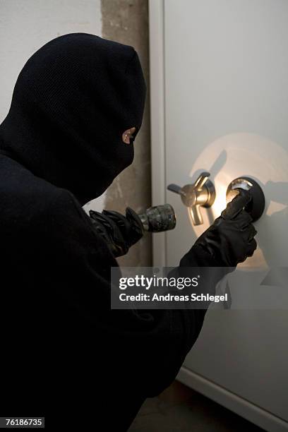 a thief unlocking a combination safe - balaclava stock pictures, royalty-free photos & images