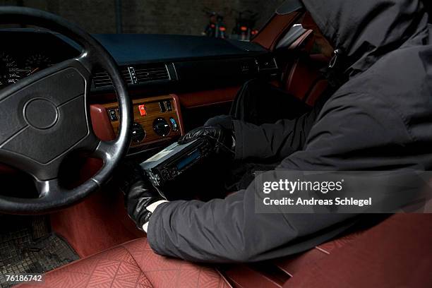 a thief stealing a car stereo - einbruch stock-fotos und bilder