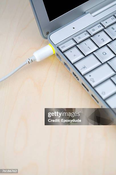 a power cable connected to a laptop - tomada de ligação à rede imagens e fotografias de stock