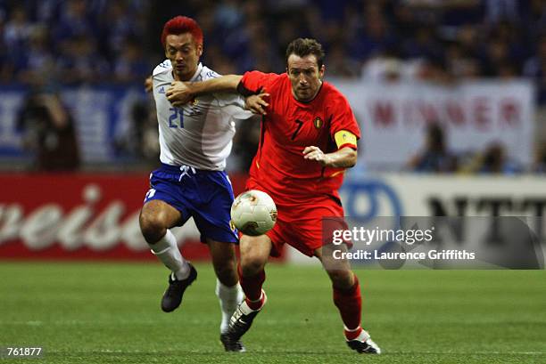 Kazuyuki Toda of Japan is held off by Marc Wilmots of Belgium in the first half during the Japan v Belgium, Group H, World Cup Group Stage match...